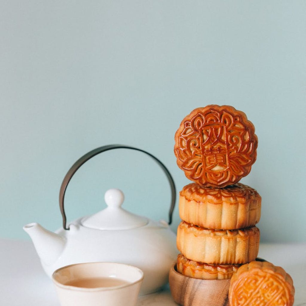 white ceramic teacup on saucer beside brown cookies